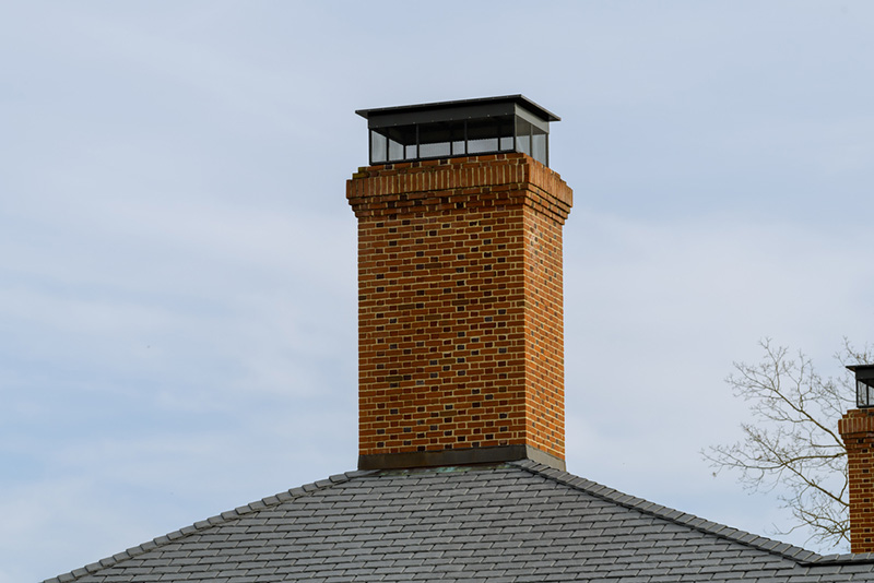 brick chimney with a black chimney cap