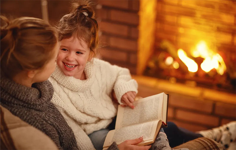 Mother and Daughter Reading By The Fire