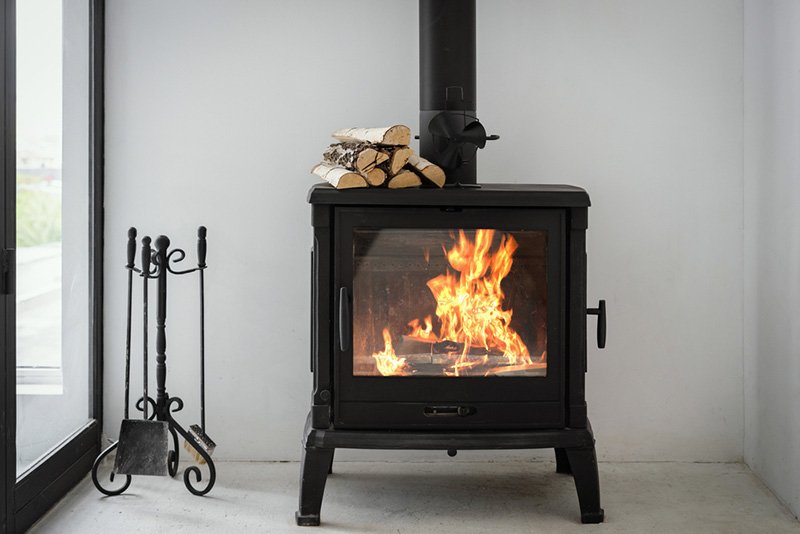 Stock Image - wood stove -Central Masonry & Chimney wood stove lit up